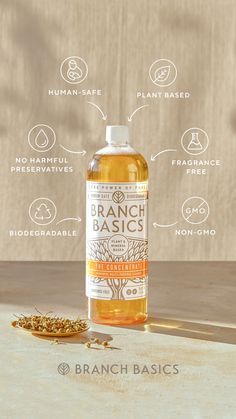 a bottle of branch basics liquid sitting on top of a table next to some seeds