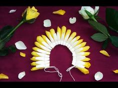 some yellow flowers and white petals on a purple table cloth with a string attached to it