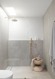 a bathroom with a sink, toilet and shower head mounted to the side of the wall