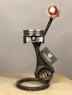 a metal object with a red light on it's head sitting on top of a wooden table