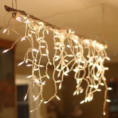 a string of lights hanging from the ceiling in a room with a mirror behind it