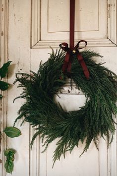 a wreath hanging on the front door of a house