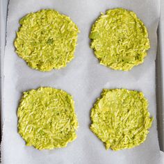 four green cookies sitting on top of a baking sheet