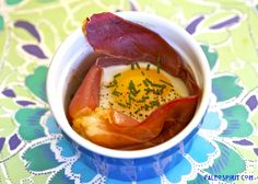 a bowl filled with bacon and eggs on top of a table