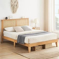 a bed sitting on top of a wooden floor next to a window