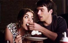 a man and woman eating cake together at a table