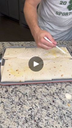 a man cutting up food on top of a counter