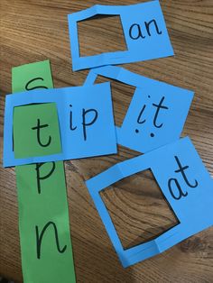 four pieces of cut out paper sitting on top of a wooden table