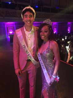 a man and woman standing next to each other in front of a crowd at a pageant