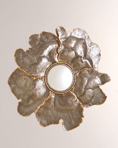 a silver flower shaped mirror hanging from the ceiling