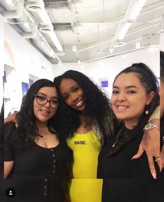 three women standing next to each other smiling