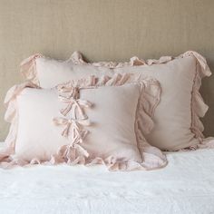 three pillows with ruffled edges on a bed