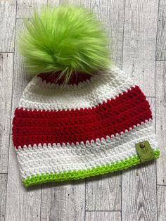 a crocheted hat with a green pom - pom on top