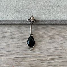 a black stone is hanging from the side of a door handle on a wooden floor