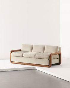 a couch sitting on top of a white floor next to a wall in an empty room