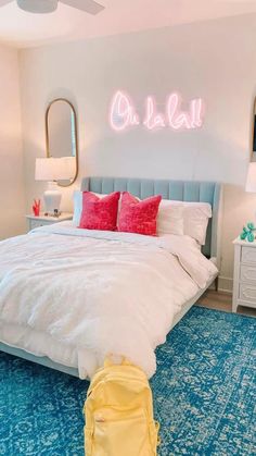 a bedroom with blue carpet, white bedding and neon lights on the wall above it