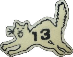 an embroidered patch with the number thirteen on it's back and a cat laying down