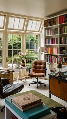 a living room filled with lots of books and furniture next to a window covered in windows