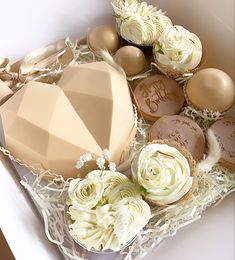 a box filled with lots of different types of cupcakes and cake toppings