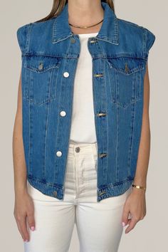 upgrade your casual rotation with this modern take on a denim vest, featuring charming ruffle shoulder details. this versatile piece offers a contemporary twist on a classic design, crafted from high-quality denim for a durable yet comfortable fit. perfect for layering over your favorite tops and dresses, this denim vest adds a touch of feminine flair and effortless cool to any outfit. 100% cotton hand wash cold | hang dry | cool iron | do not bleach do not dry clean model is wearing a size small for a more oversized look, size up Sleeveless Denim Jacket For Summer Workwear, Trendy Denim Work Vest, Trendy Denim Workwear Vest, Chic Denim Vest For Fall, Trendy Dark Wash Denim Vest For Work, Chic Dark Wash Cotton Denim Vest, Trendy Denim Vest For Layering, Trendy Spring Denim Vest For Layering, Trendy Sleeveless Denim Vest For Everyday