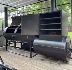 an outdoor bbq grill on the deck of a building with lots of wood and metal