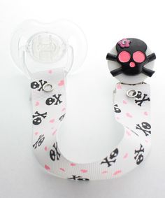 a pacifier with a black cat on it's head sitting next to a pacifier holder