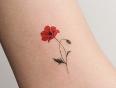 a small red flower on the side of a woman's thigh, with leaves