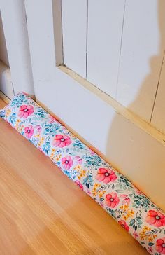 a flowered pillow sitting on the floor next to a door