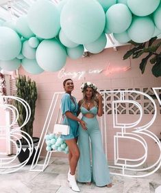 two women standing in front of some balloons