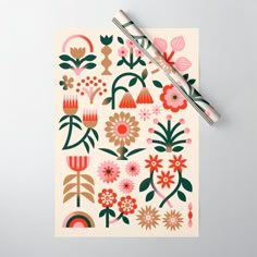 a notepad with flowers on it and a pen resting on top of the paper