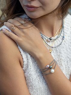 "A tribute to calming seas, this beaded pearl bracelet is a model example of Hawaii's allure. Accented with gold-filled details, this beaded beauty features scads of tiny peacock pearl beads and a single baroque freshwater pearl in a prismatic shade of white alabaster. ✦ DETAILS ✦ ✧ Name: Kaimalie (KAEE ma LEE eh) - Calm sea, quiet sea. ✧ Adjustable Length from: 6.5\"-8\". ✧ 1 White Baroque Freshwater Pearl. ✧ 2-3mm Peacock Freshwater Pearls. ✧ 14kt Gold Filled Components, Extender, and Clasp. ✧ Multi-strand Pearl Bracelets As Gift, Multi-strand Pearl Bracelet As Gift, Pearl Bead Bracelet, Black Pearl Bracelet, Tahitian Pearl Bracelet, Black Peacock, Peacock Pearls, Gold Pearl Bracelet, Calm Sea