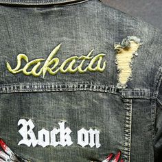 the back of a jean jacket with embroidered words on it