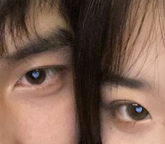 a close up of two people with blue eyes looking at something in the camera lens