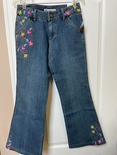 Casual Embroidered Cotton Flare Jeans, Casual Embroidered Dark Wash Bottoms, Casual Embroidered Medium Wash Jeans, Casual Dark Wash Embroidered Bottoms, Casual Embroidered Jeans In Medium Wash, Embroidered Blue Flare Jeans For Spring, Casual Dark Wash Embroidered Jeans, Blue Embroidered Flare Jeans For Spring, Embroidered Denim Blue Cotton Flare Jeans