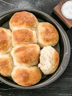 a pan filled with bread rolls on top of a wooden table