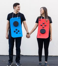 a man and woman holding hands while wearing homemade costumes