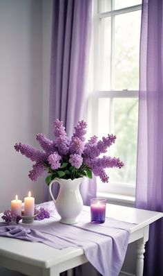 purple flowers and candles on a table in front of a window