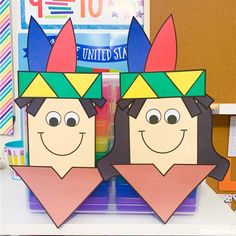 two paper cutouts of people wearing crowns on top of each other in front of a bulletin board