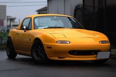 a yellow sports car parked in front of a building