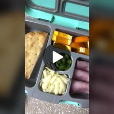 an image of a lunch box with vegetables and crackers on the side, including pita bread