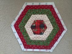 a close up of a red and green patchwork quilted hexagonal object