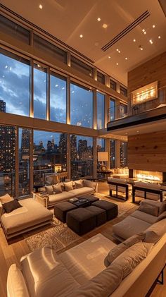 a living room filled with lots of furniture and large windows overlooking the city at night