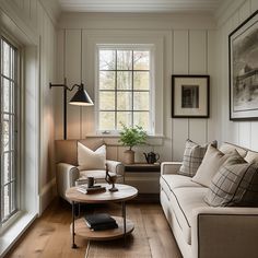 a living room with white walls and wood flooring is shown in front of a window