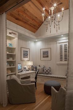 a living room filled with furniture and a chandelier hanging from the ceiling over a window