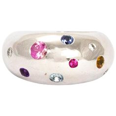 This ring holds Sapphires, Diamond, Rubies and Citrine. The multi coloured stones in this chunky 18ct white gold band are stunning. The smooth rounded band is paired perfectly with the round cut stones of all sizes. Hallmarked London 2015. Ring Size: M or 6 1/2 Band Width: 11mm White Gold Round Multi-stone Gemstones, Modern Multi-stone Gemstones For Anniversary, Modern Multi-stone Silver Gemstones, Modern Multicolored Multi-stone Gemstones, Modern Silver Multi-stone Rings, Silver Multi-stone Round Cut Gemstones, Silver Platinum Multi-stone Rings, Platinum Multi-stone Silver Rings, Simple Vintage Rings