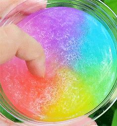 a person holding a bowl with colored powder in it