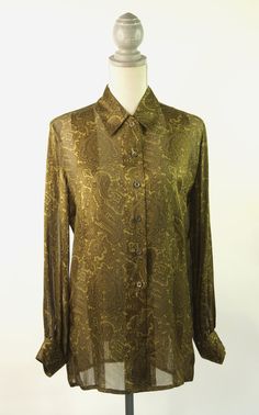 Classic vintage Escada 100% silk blouse. This loose fitting blouse is a beautiful olive green with a tone on tone paisley pattern. It closes with 6 buttons down the front. The bottom button is missing. There is one button on each cuff. Size 36.     -Measurements:     -Bust: 38 inches     -Length: 29-1/2     -Sleeve length: 23 inches Green Silk Button-up Blouse, Elegant Green Fall Shirt, Formal Green Blouse For Fall, Green Silk Formal Shirt, Formal Green Silk Shirt, Fitted Green Silk Shirt, Vintage Gold Silk Top, Classic Gold Silk Blouse, Gold Silk Blouse For Fall