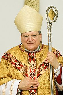 a man in a priest's outfit holding a staff