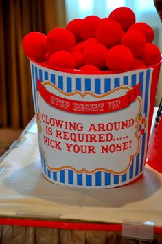 a bucket filled with red pom - poms sitting on top of a table