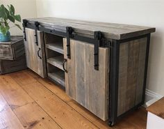 an old wooden cabinet with sliding doors on the front and bottom, in a room with hard wood flooring